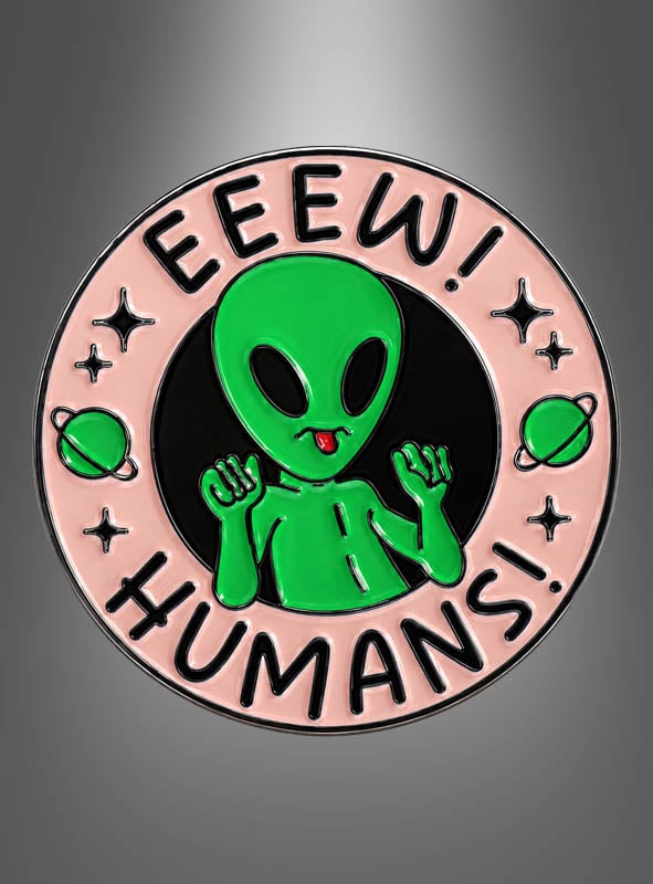 Ein runder Anstecker mit dem Namen „Alien Pins Anstecker Weltall“ zeigt einen grünen Cartoon-Außerirdischen mit erhobenen Händen, umgeben von dem Schriftzug „EEEW! MENSCHEN!“ auf einem rosa Rand, der mit kleinen Planeten und Sternen verziert ist – damit ist er die ideale Wahl für Fans von Alien Pins oder alle, die lustige Anstecker lieben.
