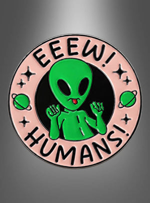 Ein runder Anstecker mit dem Namen „Alien Pins Anstecker Weltall“ zeigt einen grünen Cartoon-Außerirdischen mit erhobenen Händen, umgeben von dem Schriftzug „EEEW! MENSCHEN!“ auf einem rosa Rand, der mit kleinen Planeten und Sternen verziert ist – damit ist er die ideale Wahl für Fans von Alien Pins oder alle, die lustige Anstecker lieben.