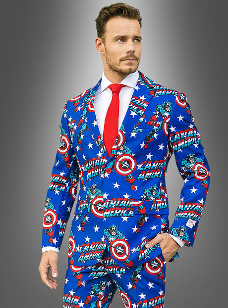Ein Mann trägt einen „Deluxe Captain America OppoSuit“-Anzug mit Comic-Motiven, dazu ein weißes Hemd und eine rote Krawatte, und steht vor einem grauen Hintergrund mit Farbverlauf.