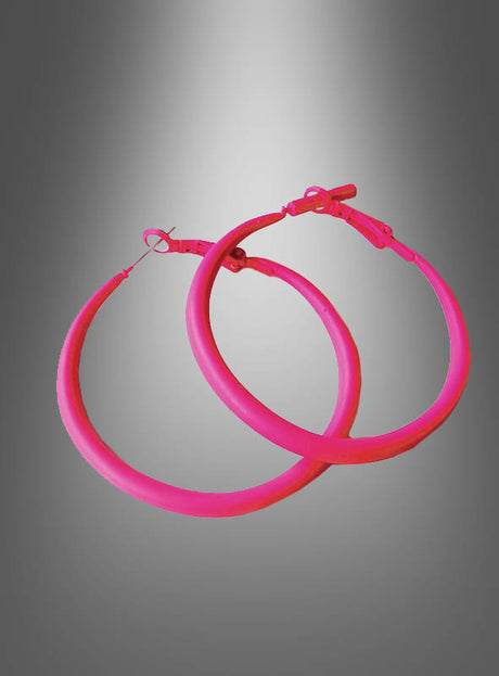 Zwei Creolen-Ohrringe im 80er-Jahre-Stil in Rosa mit Verschlüssen werden vor einem grauen Hintergrund mit Farbverlauf präsentiert.