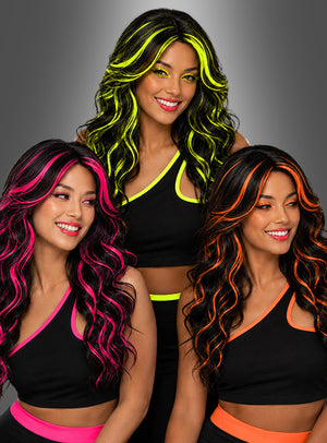 Drei Frauen mit gewelltem Haar, das mit neongelben, pinkfarbenen und orangefarbenen Strähnen durchzogen ist – sie tragen die Lange Lockenperücke „Ivy mit Neon-Strähnen“ –, posieren in schwarzen Outfits mit passenden Neon-Besätzen vor einem grauen Hintergrund.