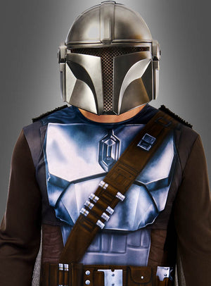 Eine Person, die das „The Mandalorian“-Kostüm für Erwachsene trägt, bestehend aus einem metallischen Helm und einer Rüstung sowie einem braunen Riemen, vor einem grauen Hintergrund.