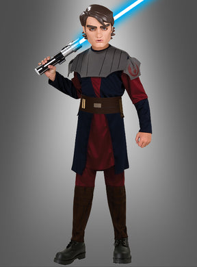 Eine Person, die das Anakin-Skywalker-Kinderkostüm aus „Clone Wars“ trägt, steht vor einem schlichten grauen Hintergrund und hält ein blaues Lichtschwert in der Hand.