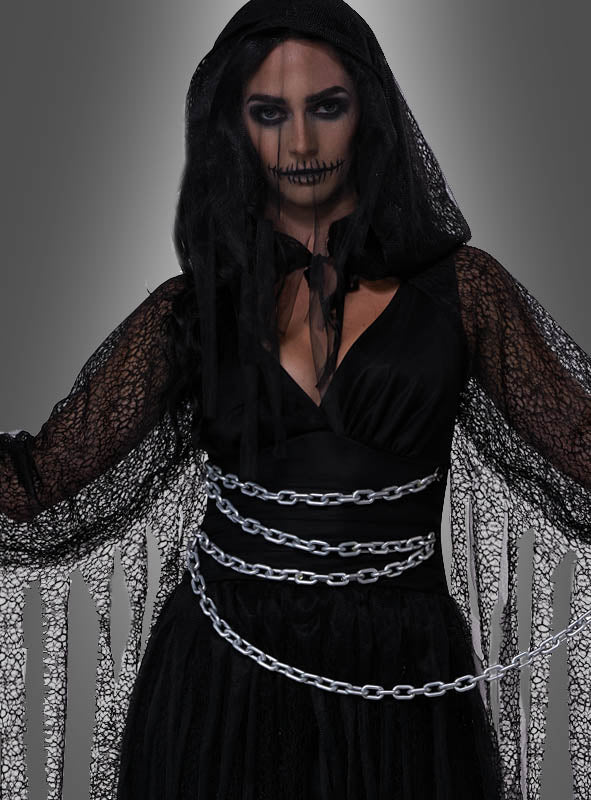 Eine Frau in einem schwarzen „Verschleierter Tod“-Damenkostüm mit Spitzendetails, dunklem Make-up, schwarzem Schleier und Ketten um die Taille steht vor einem grauen Hintergrund – ein eindrucksvolles Halloween-Kostüm für Damen.