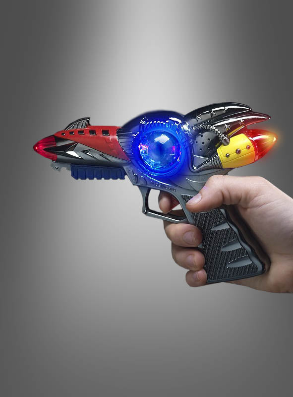 Eine Hand, die eine „Space Pistole mit Licht und Sound“ hält, deren rote, gelbe und blaue Lichter vor einem grauen Hintergrund leuchten.