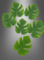 Sechs Palmenblätter als Tischdekoration für eine Hawaii-Party (15–44 cm), ideal als Dschungel-Party-Dekoration, sind auf einem grauen Hintergrund mit Farbverlauf angeordnet, wobei fünf davon oben gruppiert sind und eines unterhalb der Gruppe positioniert ist.