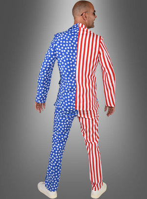 Ein Mann, der das „USA Anzug Amerika“-Kostüm trägt, dessen eine Seite blau mit weißen Sternen und die andere rot-weiß gestreift ist – die legendäre „Stars & Stripes“-Flagge –, steht vor einem grauen Hintergrund.