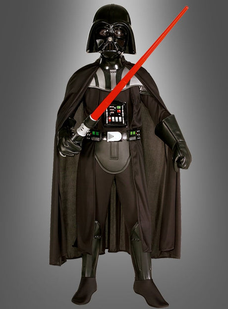 Ein Kind, das das Darth-Vader-Deluxe-Kinderkostüm trägt, steht mit Blick nach vorne und hält ein rotes Lichtschwert mit beiden Händen in der Hand, vor einem einfarbigen Hintergrund mit Farbverlauf.