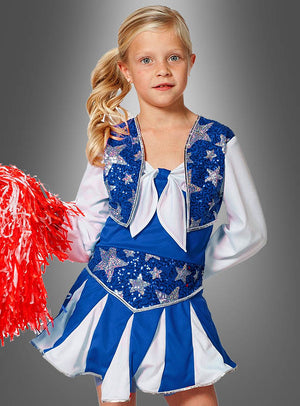 Ein junges Mädchen trägt das Cheerleader-Kostüm für Mädchen in Blau und Weiß, hält rote Pompons in den Händen und steht vor einem grauen Hintergrund mit Farbverlauf.