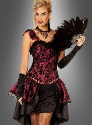Eine Frau in einem verführerischen roten Burlesque-Kleid mit schwarzen Mustern, langen Handschuhen und Netzstrumpfhosen hält vor einem grauen Hintergrund einen schwarzen Federfächer in der Hand – ideal für Karnevalsdamen, die alle Blicke auf sich ziehen wollen.