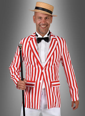 Ein Mann, der das rot-weiß gestreifte Sakko „Musical Star“ trägt – ein rot-weiß gestreiftes Sakko –, dazu eine weiße Hose, ein weißes Hemd, eine schwarze Fliege und einen Strohhut, hält einen schwarzen Spazierstock in der Hand und steht vor einem grauen Hintergrund in einem authentischen 20er-Jahre-Kostüm-Look.