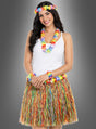 Eine Frau, die das 5-teilige Hawaii-Set mit Rock und Accessoires trägt – bestehend aus einem weißen Tanktop, einem bunten Hawaii-Rock (Grasrock) und farbenfrohem Blumenschmuck (Blumenaccessoires), der ihren Kopf, ihren Hals und ihre Handgelenke ziert –, steht vor einem schlichten grauen Hintergrund.