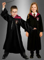 Zwei Kinder tragen das Harry-Potter-Kostüm „Gryffindor Deluxe“ – schwarze Roben mit rotem Futter und den Wappen des Hauses Gryffindor –, wobei der Junge einen Zauberstab in der Hand hält und eine Brille trägt, während das Mädchen lächelt; beide stehen vor einem grauen Hintergrund.