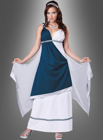 Eine Frau in einem ärmellosen blau-weißen Abendkleid mit einem durchsichtigen Umhang, silbernem Schmuck und silbernen Pumps, die vor einem grauen Hintergrund mit Farbverlauf posiert.