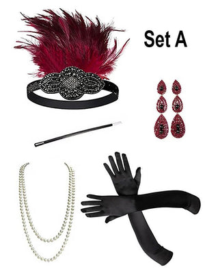Set A, bestehend aus einem Stirnband mit roten Federn und schwarzer Perlenverzierung im Kopfschmuck-Stil der 20er Jahre, einer Perlenkette, langen schwarzen Handschuhen, auffälligen roten Ohrringen und einem schwarzen Stab – das perfekte Accessoire-Set im Stil der 1920er Jahre. Das Charleston-Zubehör „1920er-Accessoire-Set mit silbernem Schmuck“ wird vor weißem Hintergrund präsentiert.