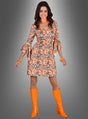 Eine Frau trägt das Kleid mit Paisleymuster, kombiniert mit orangefarbenen Stiefeln, einem orangefarbenen Halsband und orangefarbenen Armbändern, und posiert vor einem grauen Hintergrund mit Farbverlauf – eine eindrucksvolle Hommage an den lebhaften Stil eines Damenkleids aus den 70er Jahren.