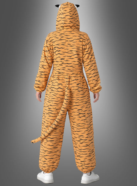 Eine Person, die ein Deluxe-Tigerkostüm aus Plüsch trägt – mit orange-schwarzen Streifen, Kapuze, Schwanz und Ohren –, steht mit dem Rücken zur Kamera vor einem grauen Hintergrund mit Farbverlauf.