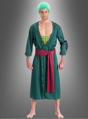 Eine Person, die das Zoro-Kostüm für Erwachsene aus „One Piece“ trägt – eine grüne Perücke, einen grünen Umhang mit roter Schärpe und ein grünes Karohemd –, steht barfuß vor einem grauen Hintergrund mit Farbverlauf; perfekt für alle, die einen authentischen Anime-Cosplay-Look suchen.