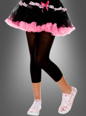 Eine Person in einem schwarz-rosa Tutu, schwarzen, blickdichten Leggings und rosa karierten Sneakers, die mit gekreuzten Beinen steht und von der Taille abwärts gezeigt wird – perfekt für ein verspieltes Karnevalskostüm.