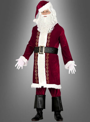 Eine Person in einem 5-teiligen Nikolauskostüm, bestehend aus einem klassischen roten Mantel, einem weißen Bart, einer Brille, einem schwarzen Gürtel, schwarzen Stiefeln mit markanten Stiefelüberzügen und weißen Handschuhen, die vor einem grauen Hintergrund steht.