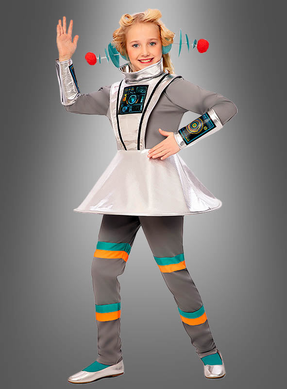 Ein Kind, das das silber-graue Retro-Raumanzug-Kostüm „Spacegirl Alien Mädchen“ mit türkisfarbenen und orangefarbenen Streifen trägt, posiert vor einem grauen Hintergrund – perfekt als Outfit für eine intergalaktische Mottoparty.