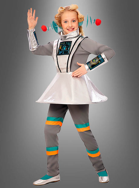 Ein Kind, das das silber-graue Retro-Raumanzug-Kostüm „Spacegirl Alien Mädchen“ mit türkisfarbenen und orangefarbenen Streifen trägt, posiert vor einem grauen Hintergrund – perfekt als Outfit für eine intergalaktische Mottoparty.