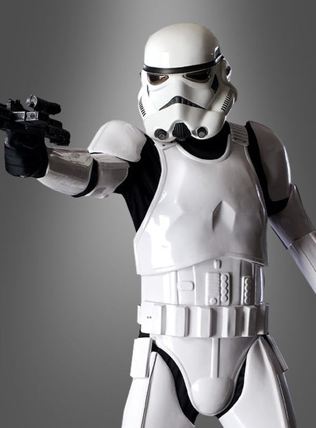 Eine Person, die das „Supreme Edition Stormtrooper Star Wars“-Filmkostüm trägt, richtet einen Blaster auf den Betrachter, während sie vor einem schlichten grauen Hintergrund steht. Dieses authentische Kostüm verfügt über einen detailreichen Sammlerhelm und ist somit ideal für Fans und Sammler gleichermaßen.