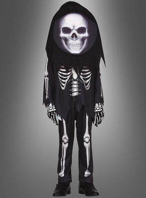 Vor einem neutralen Farbverlaufshintergrund ist ein Kind zu sehen, das das „Skelett-Kostüm mit Totenkopf für Kinder“ trägt, ergänzt durch eine große Totenkopfmaske, schwarze Handschuhe und schwarze Schuhe.