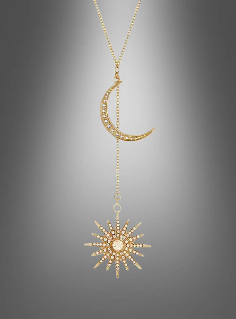 Goldfarbene Halskette „Sonne und Mond“: Diese elegante Halskette besticht durch einen funkelnden Halbmond-Anhänger mit eingefassten Steinen, der über eine feine Kette mit einem Sunburst-Anhänger verbunden ist – stilvoll arrangiert vor einem sanften, grauen Farbverlauf.