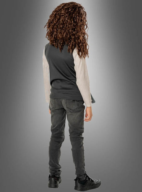 Ein Kind mit lockigem Haar, gekleidet im Deluxe-Hagrid-Kinderkostüm aus Harry Potter – bestehend aus einem dunklen Hemd mit hellen Ärmeln, grauen Jeans und schwarzen Schuhen – steht mit dem Rücken zur Kamera vor einem grauen Hintergrund mit Farbverlauf.