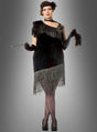 Eine Person, die das „XXL Diva 20er Jahre Fransenkleid“ trägt – ein von den 1920er Jahren inspiriertes Flapper-Kleid mit Fransen in Übergröße –, kombiniert mit schwarzen Handschuhen und einem Stirnband, hält eine Zigarettenspitze in der Hand und steht vor einem grauen Hintergrund mit Farbverlauf.