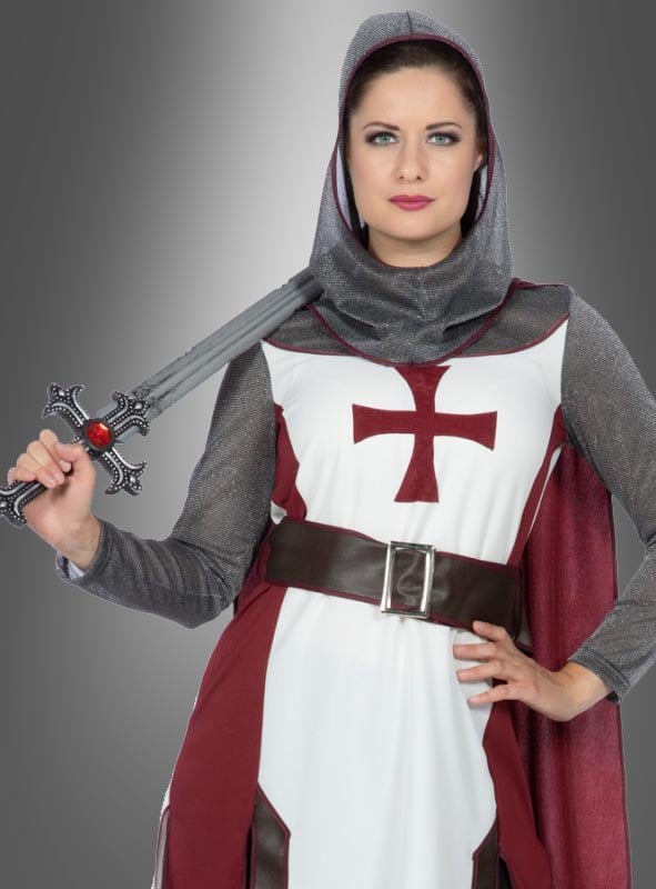 Eine Person, die das Kreuzritter-Damenkostüm „Jeanne“ trägt – bestehend aus einem mittelalterlichen Ritteroutfit mit einem roten Kreuz auf der Brust, einem Schwert und einer Kapuze –, steht vor einem grauen Hintergrund und ist damit ein echter Blickfang für alle, die sich einen authentischen mittelalterlichen Look wünschen.