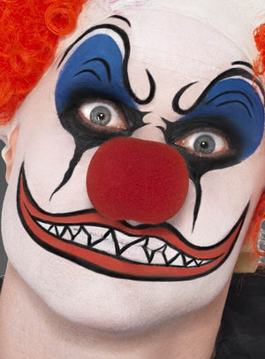 Nahaufnahme einer Person mit weißer Gesichtsbemalung aus der Schminke-Farbpalette „Fasching für Kinder und Erwachsene“, mit auffälligem blau-schwarzem Make-up, einer roten Clownsnase, einer orangefarbenen Perücke und einem groß gemalten Mund mit scharfen Zähnen – die perfekte Inspiration für Fasching- oder Kinderschmink-Motive.