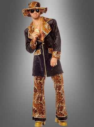 Eine Person, die das „Cooles Pimp Outfit Leopardenmuster“ trägt – komplett mit breitkrempigem Hut, Goldschmuck, Sonnenbrille und Plateauschuhen –, posiert vor einem grauen Hintergrund.