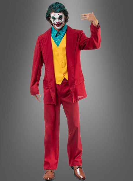 Eine Person, gekleidet in einen roten „Crazy Joker“-Anzug für Herren, dazu eine gelbe Weste, ein grünes Hemd und klassisches Clown-Make-up, steht vor einem grauen Hintergrund – perfekt für jede Superhelden-Mottoparty.