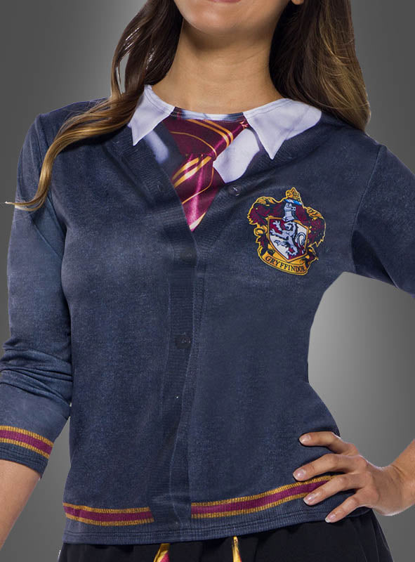 Eine Person steht mit einer Hand in der Hüfte da und trägt eine blaue Strickjacke mit weißem Kragen und Gryffindor-Wappen, die über dem bedruckten Harry-Potter-Shirt „Gryffindor“ liegt.