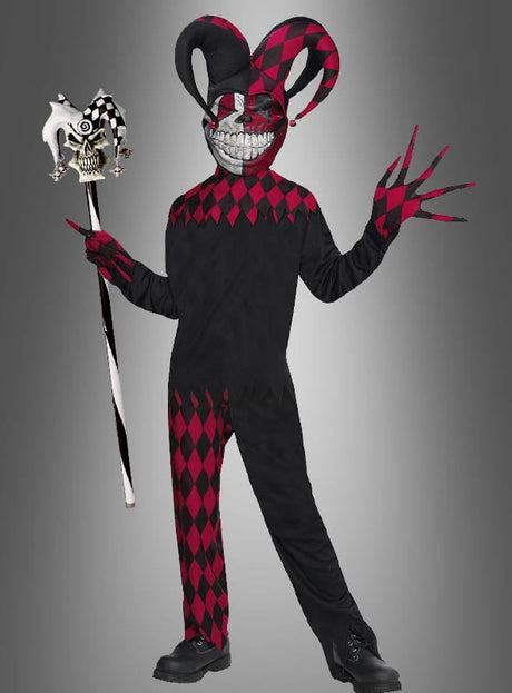 Vor einem grauen Hintergrund steht eine Person im „Jester Grusel Clown Kinderkostüm“ – ein schwarz-rotes Narrenkostüm mit einer großen Maske, die ein unheimliches Grinsen zeigt –, die einen Narrenstab in der Hand hält und Handschuhe mit langen, spitzen Fingern trägt.