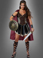 Vor einem grauen Hintergrund steht eine Frau, die das „Sexy Gladiatorin“-Kostüm „Kriegerin“ trägt – mit einem roten Umhang, schwarzer Rüstung, Sandalen und Armbändern – und einen runden Schild sowie ein Schwert in den Händen hält.