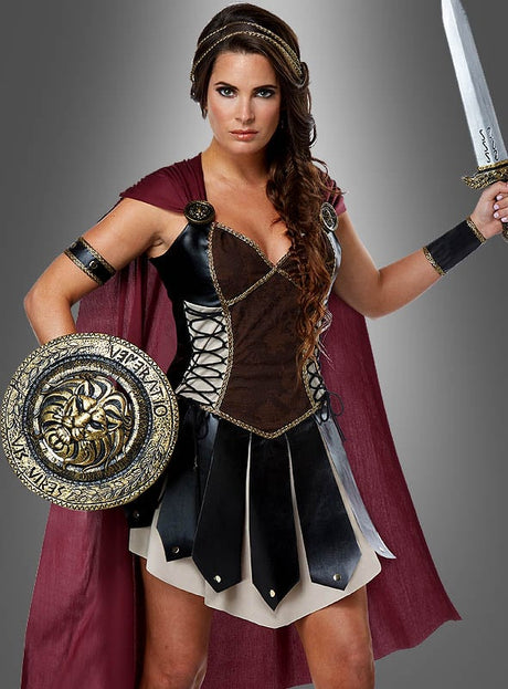 Eine Frau im „Sexy Gladiatorin“-Kostüm als Kriegerin, ausgestattet mit einem Schwert, einem runden Schild, einem roten Umhang, einem Lederrock und Armbändern, steht vor einem grauen Hintergrund.