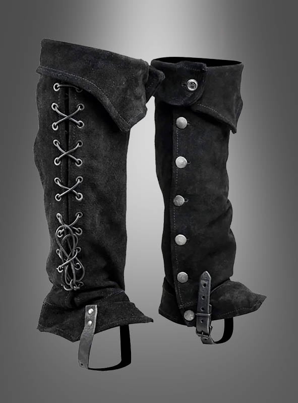 Die aus schwarzem Wildleder gefertigten Gamaschen-Stiefelüberzieher „Piraten & Steampunk“ sind auf der einen Seite mit Schnürsenkeln versehen und lassen sich auf der anderen Seite mit Knöpfen und einer Schnalle schließen. Sie werden vor einem grau verlaufenden Hintergrund präsentiert – und sind damit das ideale Kostümzubehör für einen eleganten letzten Schliff.