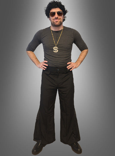 Ein Mann, der das „70er Disco-Fever-Set mit Schlaghose für Herren“ trägt – bestehend aus einer schwarzen Perücke, einer Sonnenbrille, einer Dollarzeichen-Halskette, einem dunklen Hemd und einer klassischen schwarzen Schlaghose – steht mit den Händen in den Hüften vor einem grauen Hintergrund. Damit ist dieses Set die perfekte Wahl für alle, die auf der Suche nach einem kultigen 70er-Jahre-Kostüm für Herren oder einem Disco-Outfit für Männer sind.
