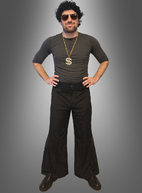 Ein Mann, der das „70er Disco-Fever-Set mit Schlaghose für Herren“ trägt – bestehend aus einer schwarzen Perücke, einer Sonnenbrille, einer Dollarzeichen-Halskette, einem dunklen Hemd und einer klassischen schwarzen Schlaghose – steht mit den Händen in den Hüften vor einem grauen Hintergrund. Damit ist dieses Set die perfekte Wahl für alle, die auf der Suche nach einem kultigen 70er-Jahre-Kostüm für Herren oder einem Disco-Outfit für Männer sind.