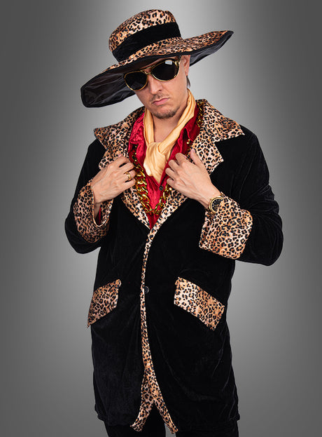 Im Zuhälter-Kostüm „Daddy Cool Pimp“ (Größen M–XXXL) – einem auffälligen schwarzen Samtmantel mit Leopardenmuster-Besatz, einem passenden Hut mit breiter Krempe, eine Sonnenbrille, eine goldene Uhr und übereinander getragene Seidenschals – steht diese Person vor einem grauen Hintergrund mit Farbverlauf und verkörpert damit den unverkennbar kühnen Stil des klassischen „Daddy Cool“-Looks.