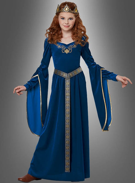 Ein junges Mädchen mit langen roten Haaren trägt eine goldene Krone und das „Mittelalter-Kleid Bluebird Prinzessin“, ein wunderschönes langes blaues Mittelalterkleid für Mädchen mit eleganten goldenen Verzierungen, und steht vor einem grauen Hintergrund.