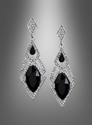 Elegante Silberohrringe für Damen mit großen schwarzen Edelsteinen und kleinen klaren Kristallen in geometrischen Mustern, präsentiert vor einem grauen Hintergrund mit Farbverlauf.