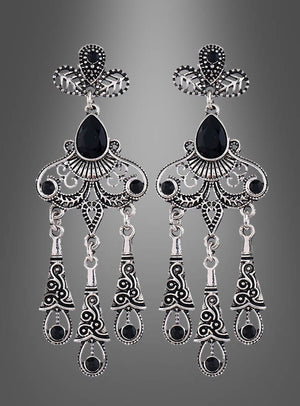 Elegante Ohrringe für Damen aus Silber mit filigranem Design, schwarzen Edelsteinen und drei beweglichen Anhängern pro Ohrstecker, präsentiert vor einem grauen Hintergrund mit Farbverlauf.