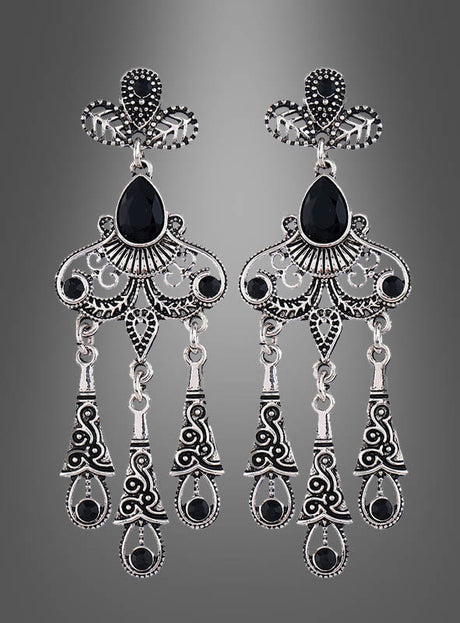 Elegante Ohrringe für Damen aus Silber mit filigranem Design, schwarzen Edelsteinen und drei beweglichen Anhängern pro Ohrstecker, präsentiert vor einem grauen Hintergrund mit Farbverlauf.