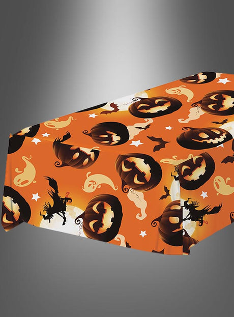 Rechteckiger Tisch, gedeckt mit der Mehrweg-Tischdecke „Halloween Kürbisse“ mit Motiven wie Kürbislaternen, Geistern, Fledermäusen und Hexen – perfekt als festliche Halloween-Dekoration.