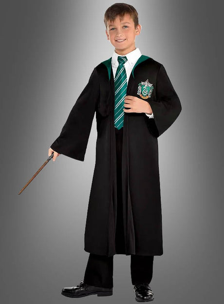 Ein kleiner Junge trägt den Slytherin-Umhang von Draco Malfoy aus „Harry Potter“, dazu ein weißes Hemd, eine grün gestreifte Krawatte und eine schwarze Hose. Er hält einen Zauberstab in der Hand und steht vor einem schlichten grauen Hintergrund – eine ideale Wahl für jeden jungen „Harry Potter“-Fan.