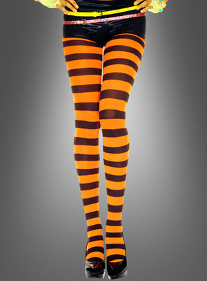 Eine Person trägt schwarze Shorts, breit gestreifte Ringelstrumpfhosen (orange-schwarz) und schwarze High Heels und steht vor einem einfarbigen grauen Hintergrund mit Farbverlauf.